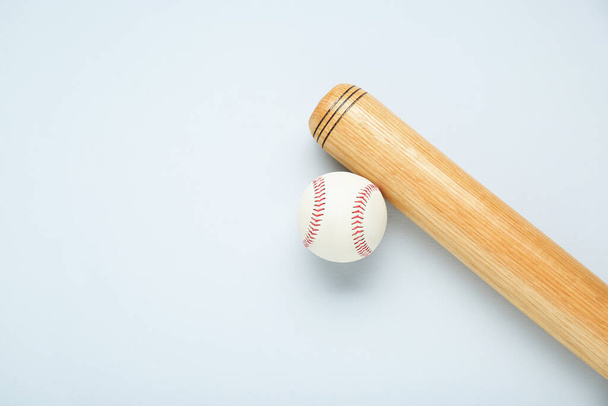 Wooden baseball bat and ball on light grey background, flat lay. Space for text - Foto, afbeelding