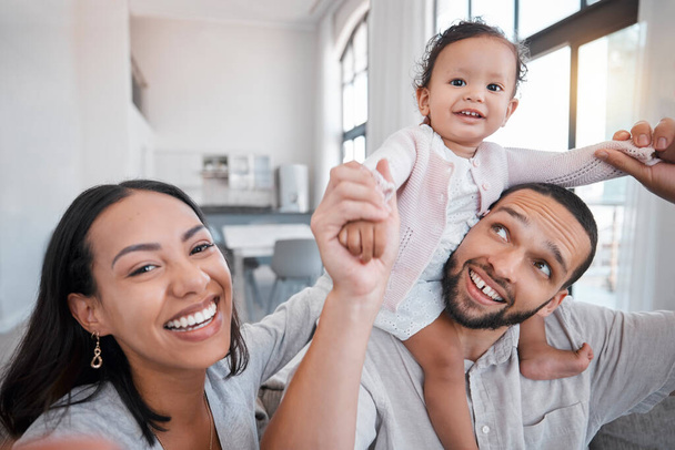 Family, portrait and playing with a mother, father and baby girl being playful and cheerful in the family home. Fun, funny and man and woman loving, caring and carrying little girl for comic bonding. - Photo, Image