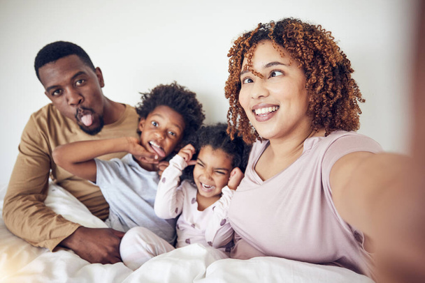 Black family, selfie and funny face portrait in home bedroom, smile and having fun together. Interracial, comic and father, mother and children taking pictures for happy memory and social media - Photo, Image