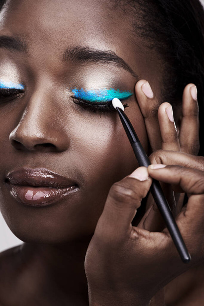 Color me beautiful. Studio shot of a beautiful young woman applying eye makeup - Фото, изображение