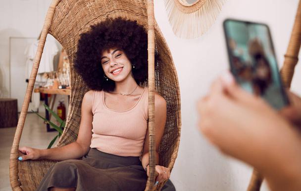 Schwarze Frau, Lächeln und Schaukelstuhl mit einem Handy für ein Foto für soziale Medien, Blog oder Online-Marketing oder Werbung. Gesicht der Influencerin glücklich, während sie für Profilbild als Netznutzerin posiert. - Foto, Bild