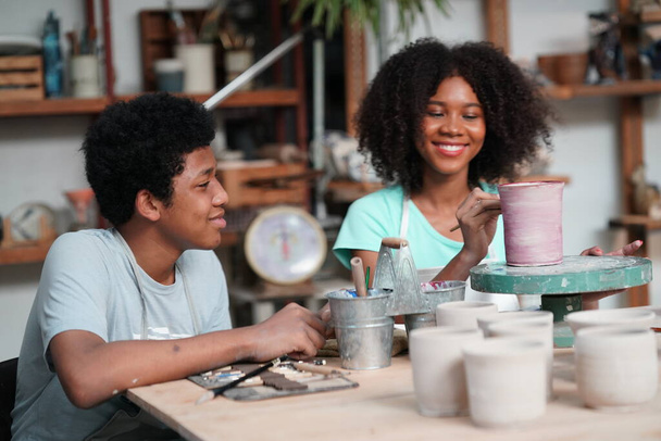 Jovem afro menina e menino em oficina de cerâmica, proprietário do negócio.  - Foto, Imagem