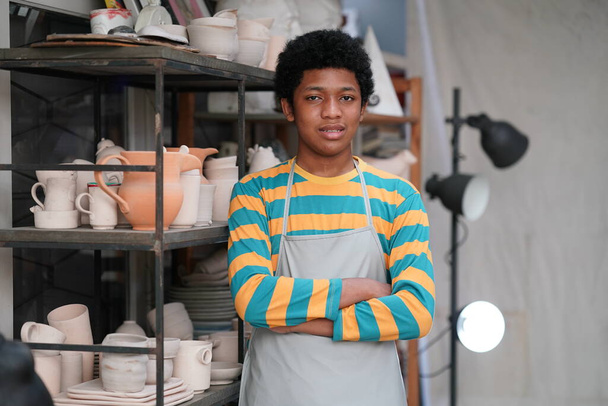 jong Afro tiener hand pottenbakker maken klei vaas in aardewerk workshop - Foto, afbeelding