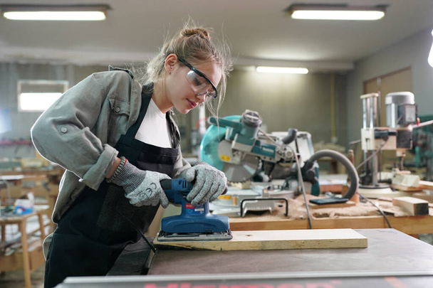 Young beautiful woman doing work in the carpenter DIY workshop room. Small Business owner, young woman who working at furniture factory. - Fotoğraf, Görsel