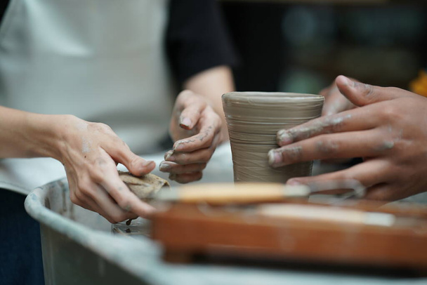 Hermosa mujer haciendo cerámica de cerámica en el volante, manos de cerca. Concepto para mujer en freelance, negocios, hobby
 - Foto, imagen