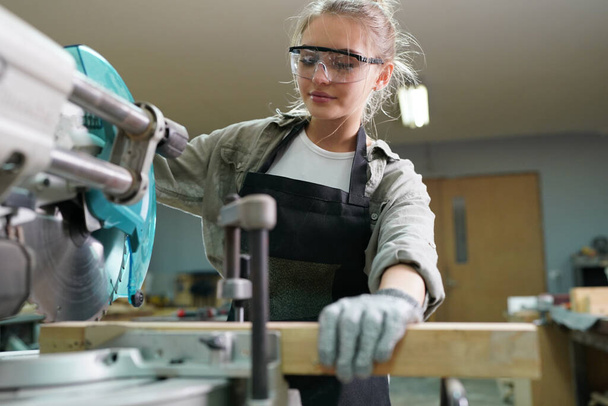 Small business of a young woman. Beautiful young woman worker in a furniture workroom - Foto, imagen