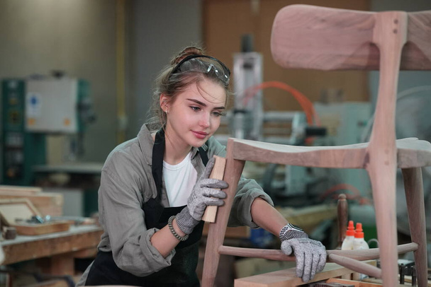 Piccola impresa di una giovane donna. Bella giovane lavoratrice in un laboratorio di mobili, misurando il legno. - Foto, immagini
