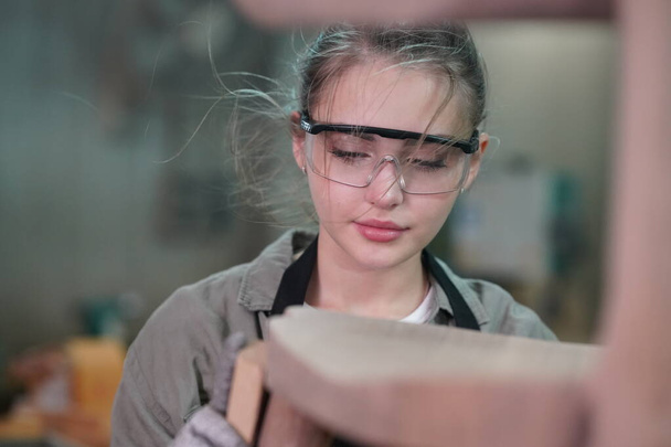 Small business of a young woman. Beautiful young woman worker in a furniture workroom - Photo, image