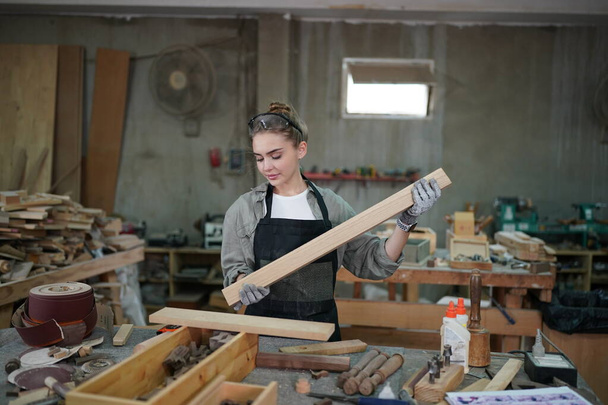 Small business of a young woman. Beautiful young woman worker in a furniture workroom - Valokuva, kuva