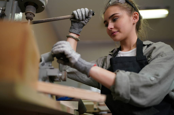 Small business of young woman. Beautiful young woman worker in a furniture workroom - Fotó, kép
