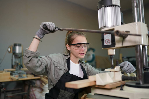 Small business of a young woman. Beautiful young woman worker in a furniture workroom - 写真・画像
