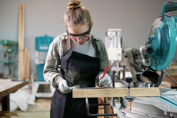 Small business of young woman. Beautiful young woman worker in a furniture workroom - Фото, зображення