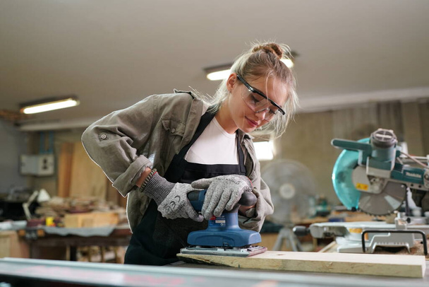 Kleines Geschäft einer jungen Frau. Schöne junge Arbeiterin in einer Möbelwerkstatt - Foto, Bild