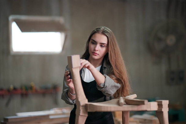 Pequeño negocio de una mujer joven. Hermosa joven trabajadora en un taller de muebles - Foto, Imagen