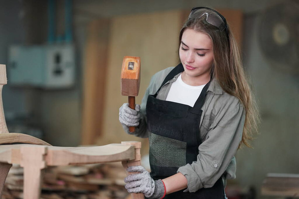 Kleines Geschäft einer jungen Frau. Schöne junge Arbeiterin in einer Möbelwerkstatt, die Holz misst. - Foto, Bild