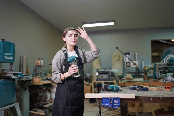 Kleines Geschäft einer jungen Frau. Schöne junge Arbeiterin in einer Möbelwerkstatt - Foto, Bild