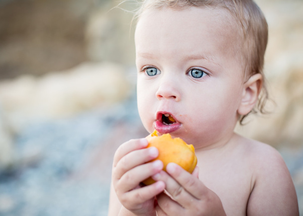 niedliche Kleinkind Junge isst eine Aprikose - Foto, Bild