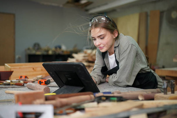 Small business of a young woman. Beautiful young woman worker in a furniture workroom - Fotografie, Obrázek