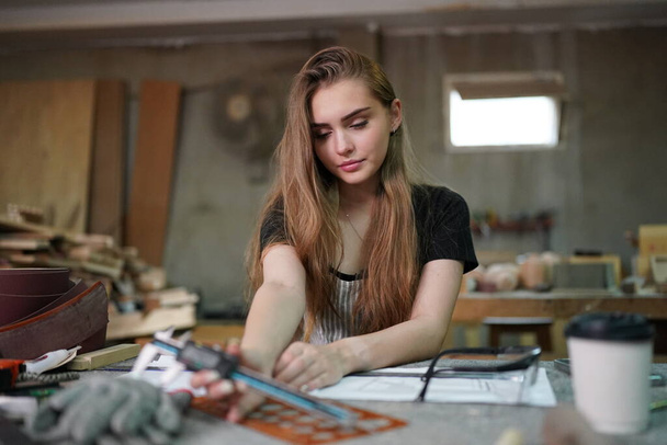 Small business of young woman. Beautiful young woman worker in a furniture workroom - Valokuva, kuva