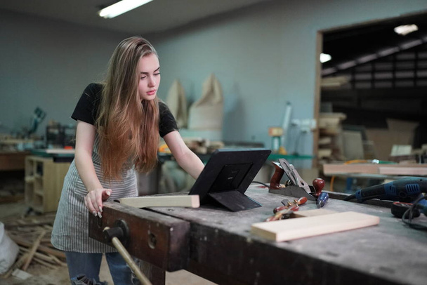 Small business of a young woman. Beautiful young woman worker in a furniture workroom - Fotoğraf, Görsel