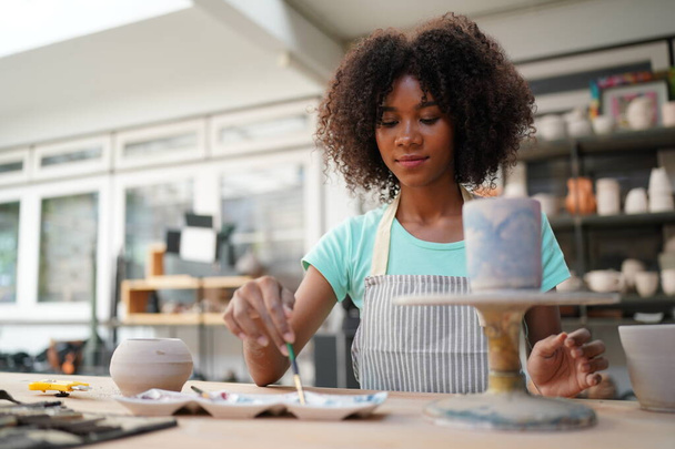 Giovane ragazza afro in laboratorio di ceramica, imprenditore - Foto, immagini