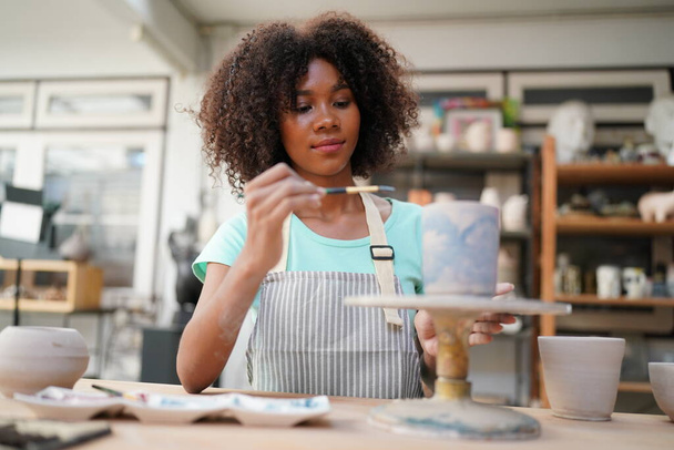 Giovane ragazza afro in laboratorio di ceramica, imprenditore - Foto, immagini
