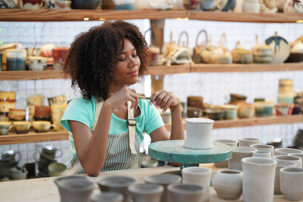 Молодая афро девушка в мастерской керамики, владелец бизнеса - Фото, изображение