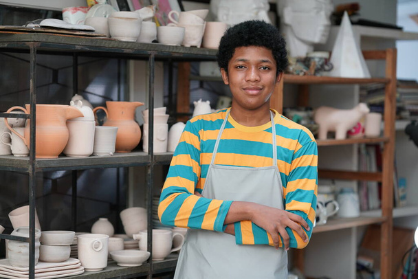 jong Afro tiener hand pottenbakker maken klei vaas in aardewerk workshop - Foto, afbeelding