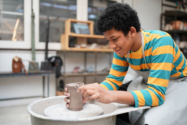Portret van een creatieve pottenbakker of ondernemer met keramische producten in de pottenbakkerij - Foto, afbeelding