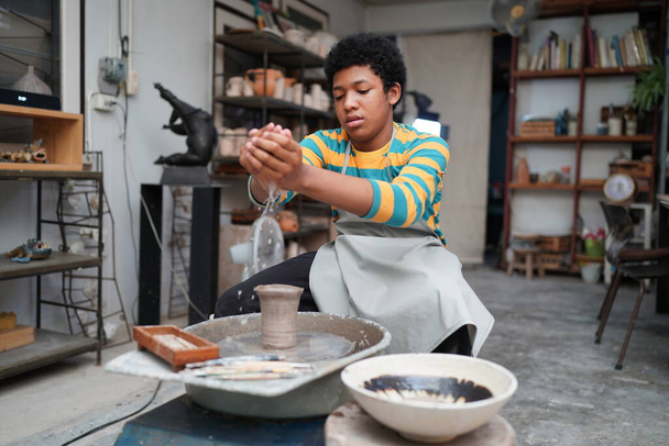 Junger Afro-Teenager töpfert in Töpferwerkstatt Tonvase - Foto, Bild