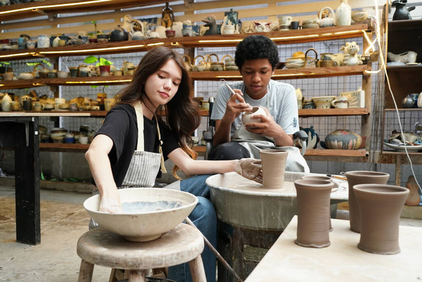 Portrait of a creative potter artisrt or business owner with ceramic products at the pottery shop - 写真・画像