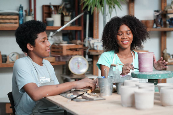 Giovane ragazza afro e ragazzo in laboratorio di ceramica, imprenditore.  - Foto, immagini