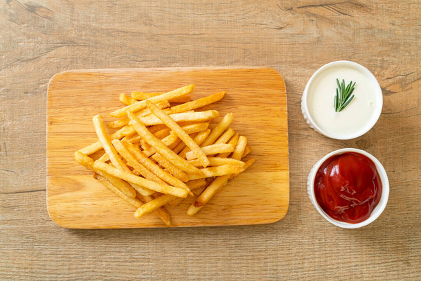 French fries or potato chips with sour cream and ketchup - 写真・画像