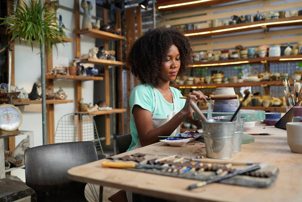 Young Afro girl in pottery workshop, Business owner - 写真・画像