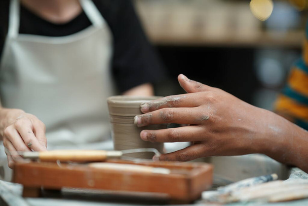 Mooie vrouw maken van keramische pottenbakkerij op wiel, handen close-up. Concept voor vrouw in freelance, business, hobby - Foto, afbeelding