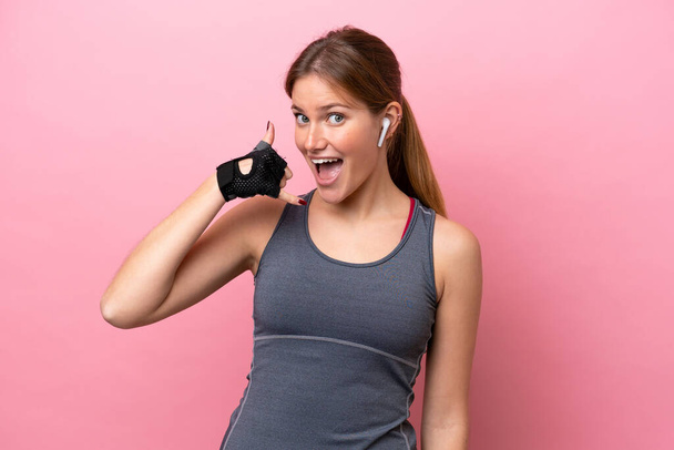 Mujer joven deporte caucásico aislado sobre fondo rosa haciendo gesto de teléfono. Llámame señal de vuelta - Foto, Imagen