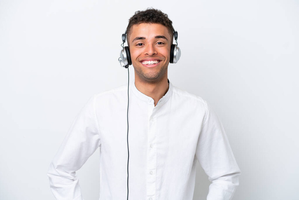 Telemarketer brasilianischer Mann arbeitet mit einem Headset auf weißem Hintergrund und lacht - Foto, Bild