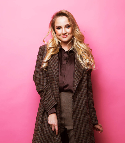 Beautiful young woman long blond curly hair wear cashmere coat over pink background - Foto, Imagem