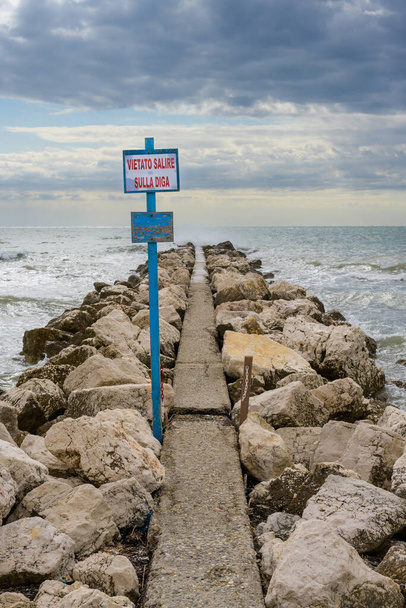 Breakwater Dam on Lido di Venezia Beach in Venice, Italy with Sign reading Vietato Salire Sulla Diga - It is forbidden to climb the Dam - Zdjęcie, obraz