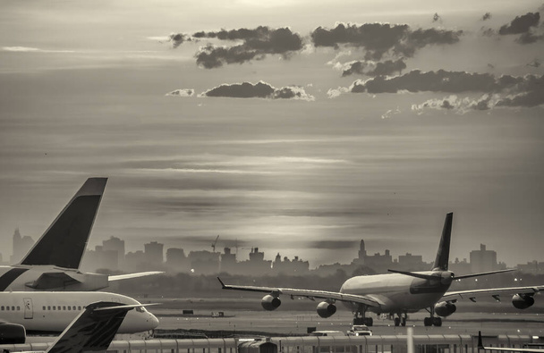 Backlit view of airplanes on the airport runway at sunset. Travel around the world concept. - Foto, immagini