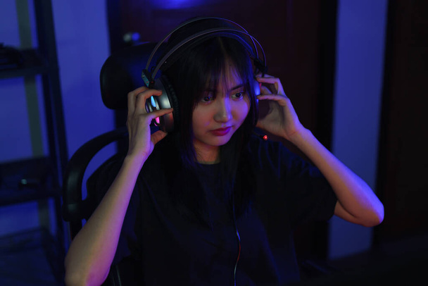Nainen cyber hakkeri gamer kuulokkeissa katsomassa videopeli monitorista hakkerointi ohjelmointijärjestelmä. - Valokuva, kuva
