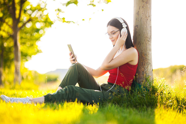 dark hair girl listening to music with a headphones from her smartphone - Photo, image