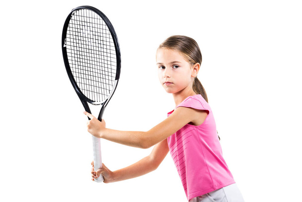Young female tennis player in pink outfit. Little girl posing with racket and ball isolated on white background. - Foto, Imagen