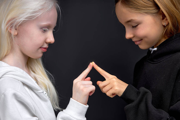 two best friends has their own body secret language, children joining their fingers , shows unity , friendship , fun isolated black background - Fotoğraf, Görsel