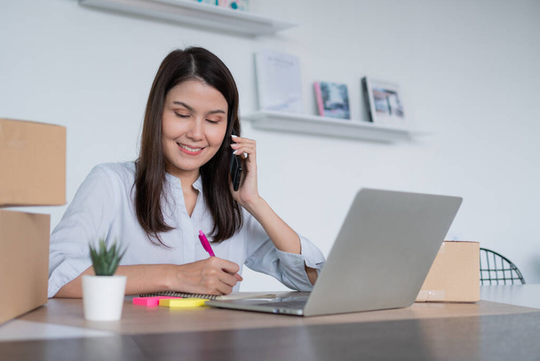 Счастливая молодая азиатская женщина-предприниматель, поговорите с поставщиком и улыбка для продажи успех интернет-магазина в домашнем офисе, Концепция торговца, малого бизнеса, интернет-бизнеса, и электронной коммерции. - Фото, изображение