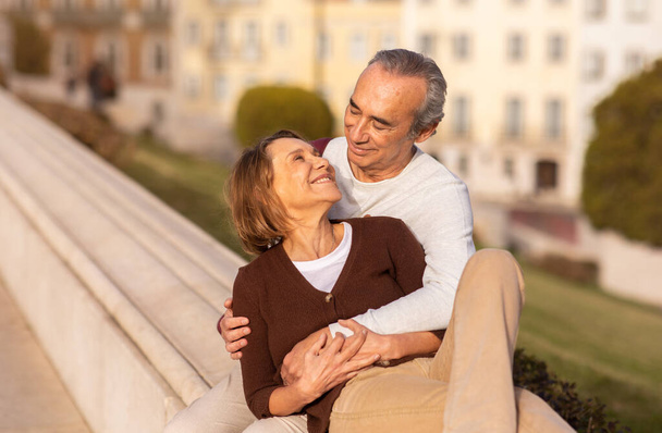 Glückliches Seniorenpaar, das sich umarmt und das Wochenende im Freien genießt. Ehemalige Ehepartner, die unterwegs sind und Zeit miteinander verbringen. Langlebige Ehe und zurückgezogenes Lifestyle-Konzept - Foto, Bild