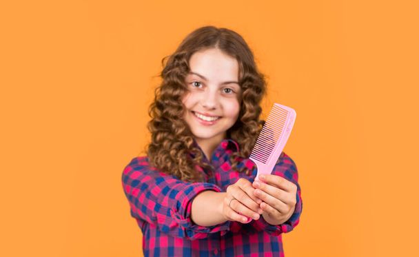 Small girl hairdresser salon. Brushing long hair. Enjoying shiny curls. Balm oil conditioner for styling. Hairstyle for party. Hairdresser supplies. Little child curly hair. Fashion and beauty. - Φωτογραφία, εικόνα