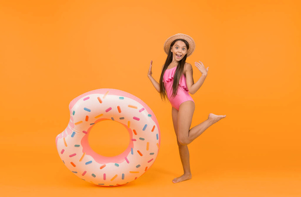 Safety on water. Safety measures around pool to keep bathers safe. Little girl and swimming donut ring. Kid in swimsuit having fun. Summer vacation. Swimming and sunbathing. Accessories for swimming. - Foto, afbeelding