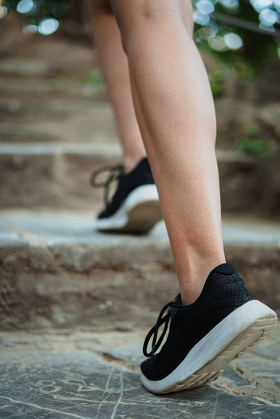 Close up shot of girl running up stone stairs to work out in a park. - Foto, Bild