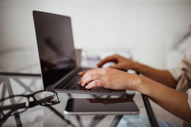 Kädet nuori aasialainen nainen kirjoittamalla tietokoneeseen pöydässä puhelimen tyhjä näyttö huoneen sisustus, rajattu. Opiskelu, työ, liiketoiminta ja freelance kotona uusi normaali tekniikka - Valokuva, kuva